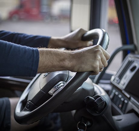 image of man with his hands on the driver's wheel in a truck