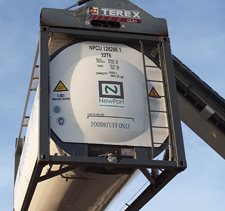 white ISO bulk container being lifted in the air by a crane 