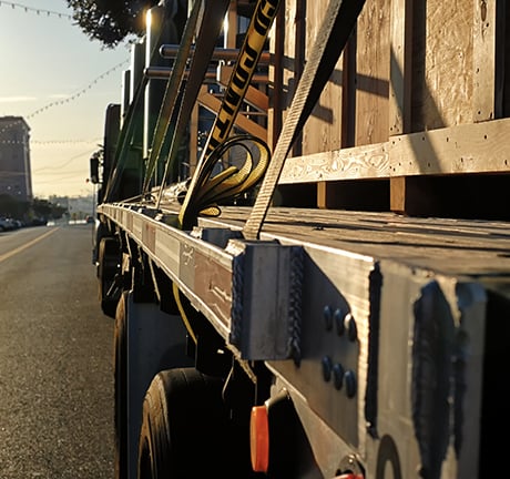 image of the side of a flatbed truck on a street with a sunset in the background