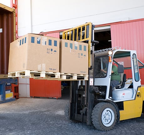 fork-lift loading product into a truck from a warehouse