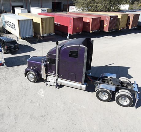 Purple shipping truck in a container yard